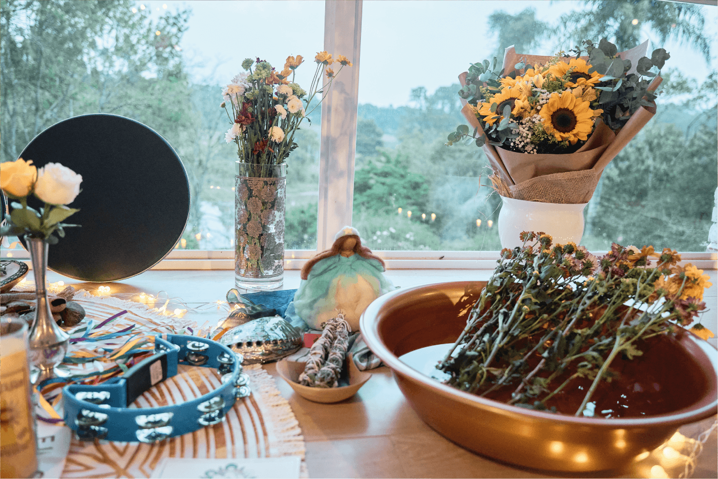 Altar organizado com imagens, ervas, instrumentos musicais e flores.