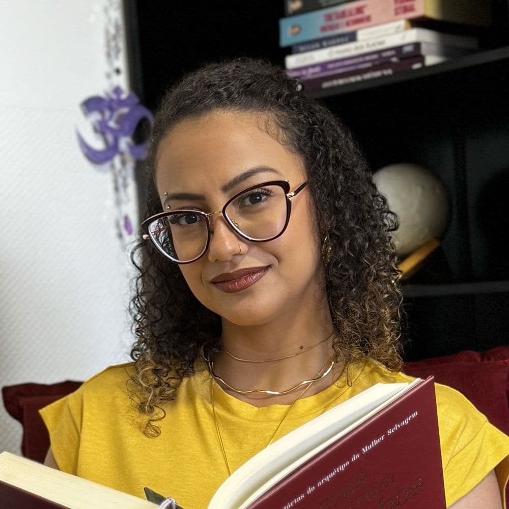 Tatiane Sobrinho de amarelo segurando livro.